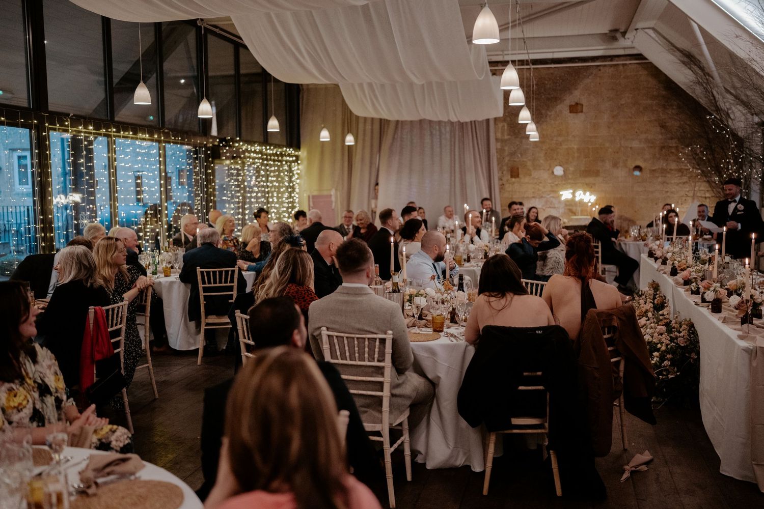Historic brick barn venue with diamond pattern brickwork and guests gathered outside at oak farm near Ledbury, England.