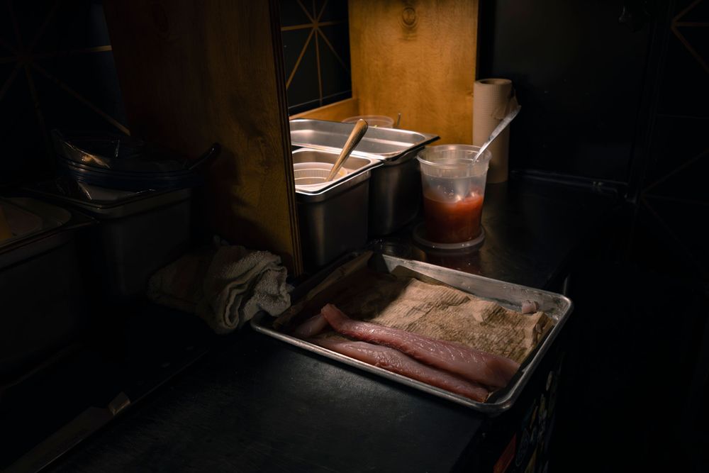 Dark and moody shot of a professional kitchen during food preparation.