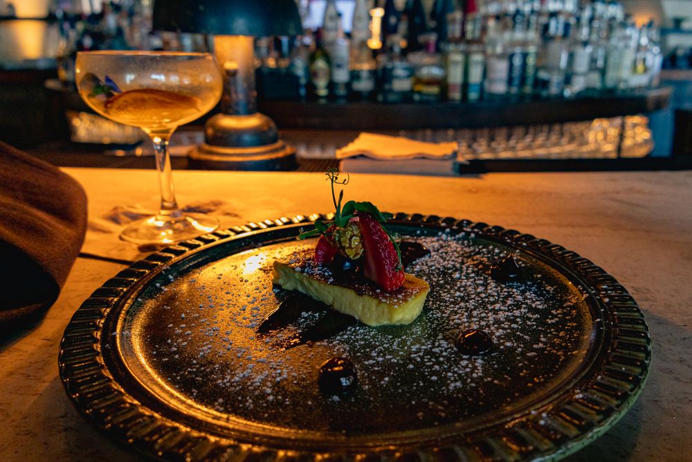 Elegant black plates with artistic food presentation and decorative elements in warm lighting.