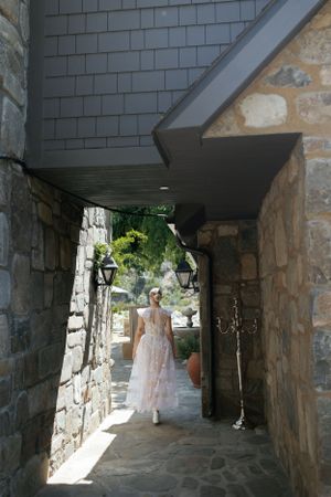 A light-filled stone archway and corridor creates a romantic passageway at a wedding venue.