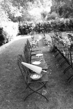 Black and white photo of empty folding chairs set up for an outdoor ceremony.