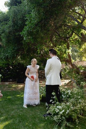 A romantic garden moment between newlyweds surrounded by lush greenery.