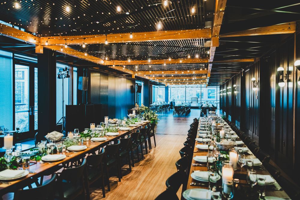 Modern District Winery DC interior with warm lighting features long communal tables and string lights creating an inviting ambiance.