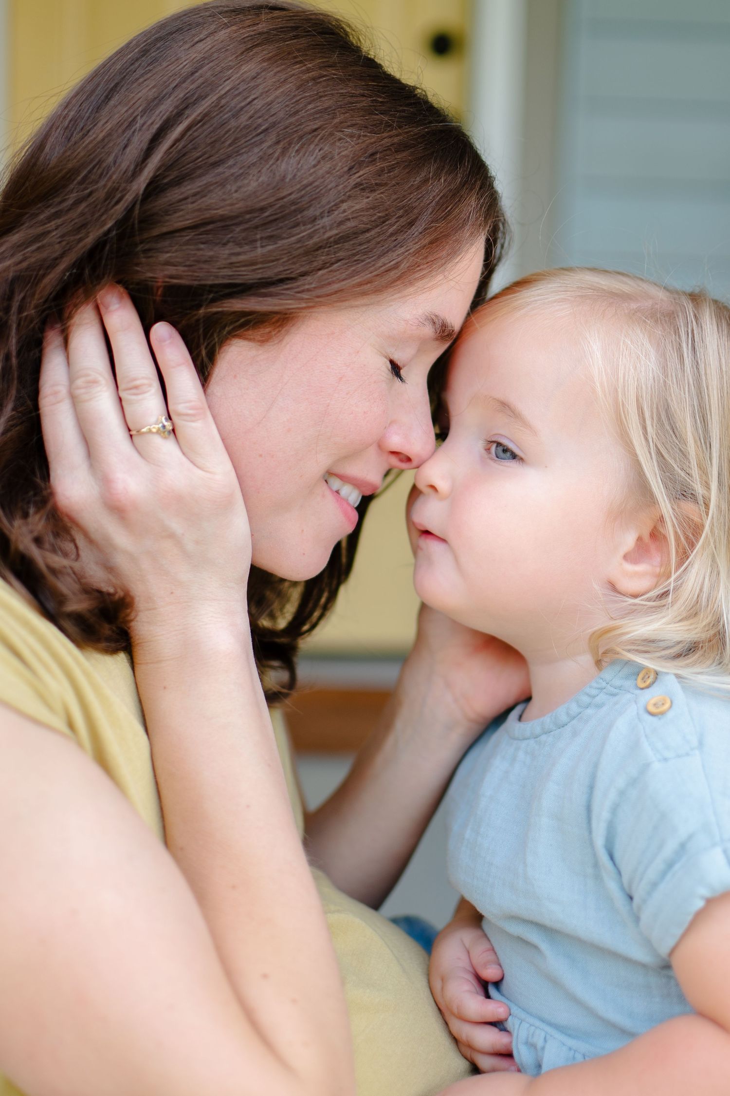 A tender moment is shared between parent and child on their front porch.