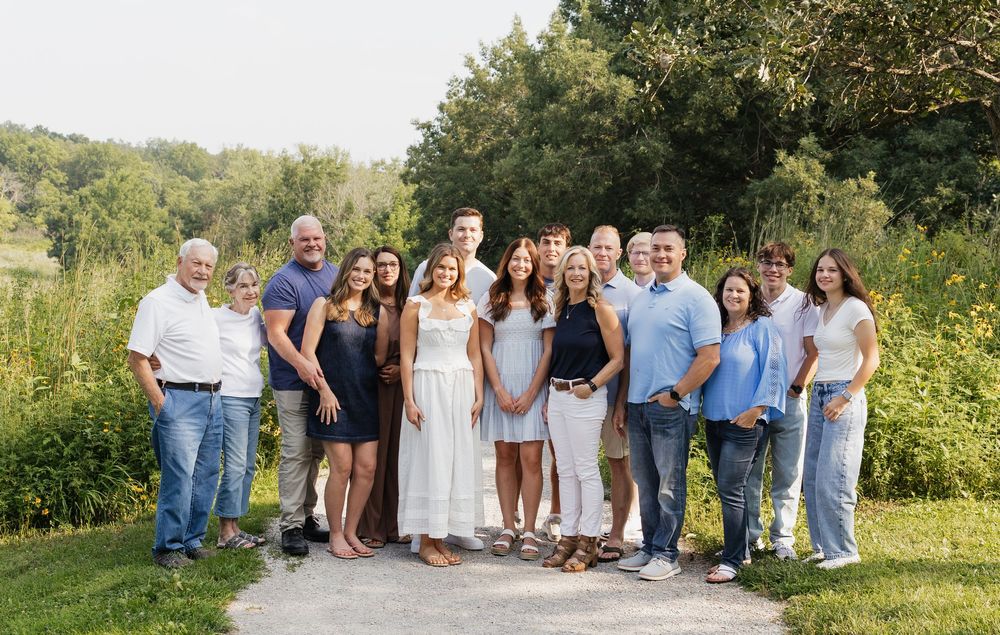 A panoramic collage of group photos taken outdoors in a natural setting with greenery and sunlight.