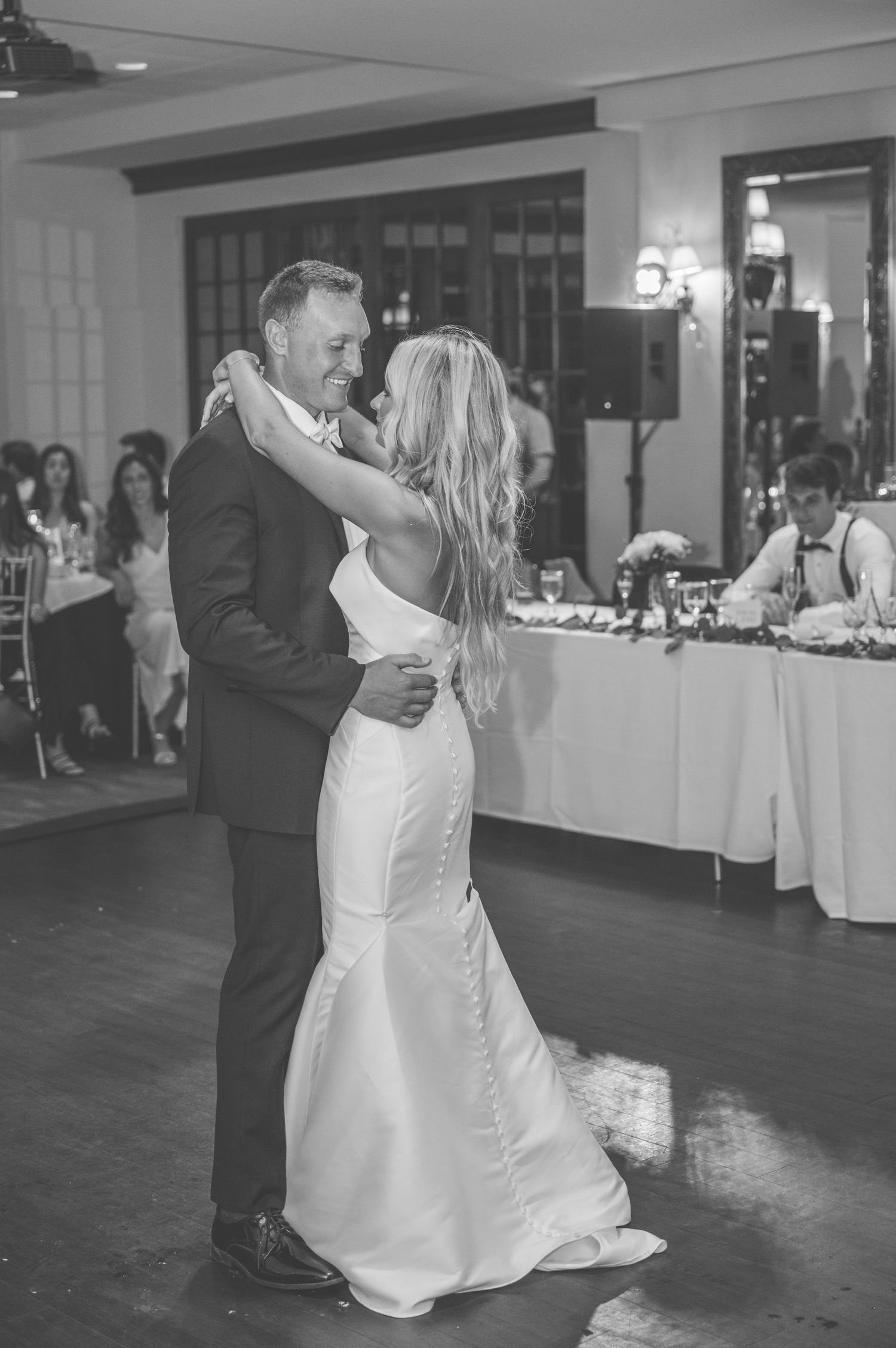 Black and white photos capture romantic first dance moments between newlyweds on their wedding day.