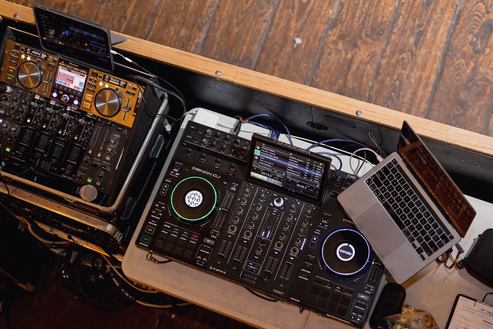 Professional DJ equipment setup with controllers and laptop for wedding entertainment.