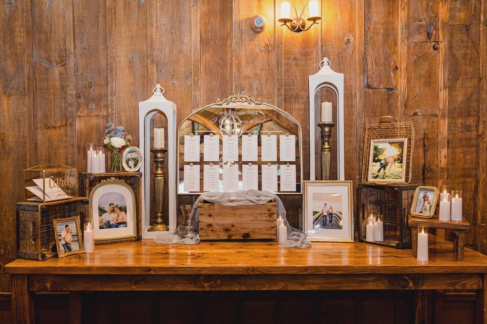 Rustic barn wedding venue interior with wooden walls decorated with vintage decor and string lights.