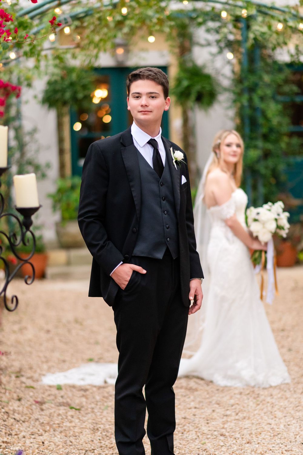 A wedding scene in a garden courtyard with string lights and elegant formal attire.