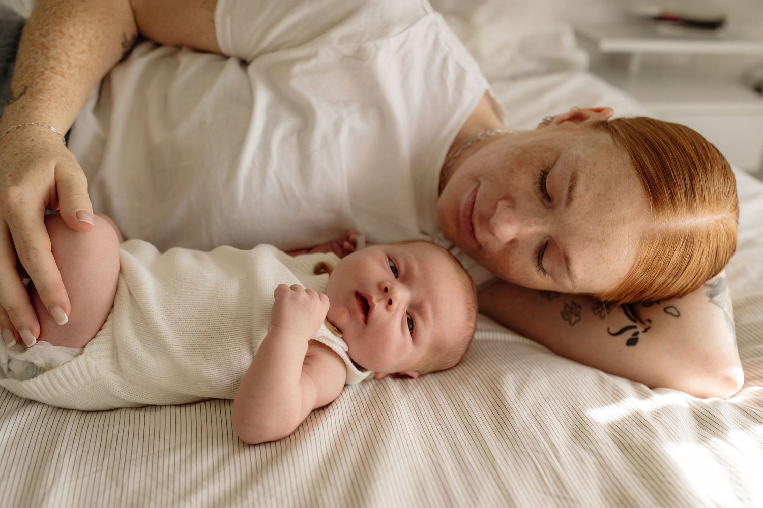 Mum cuddling newborn baby during relaxed in-home newborn photography session in Auckland