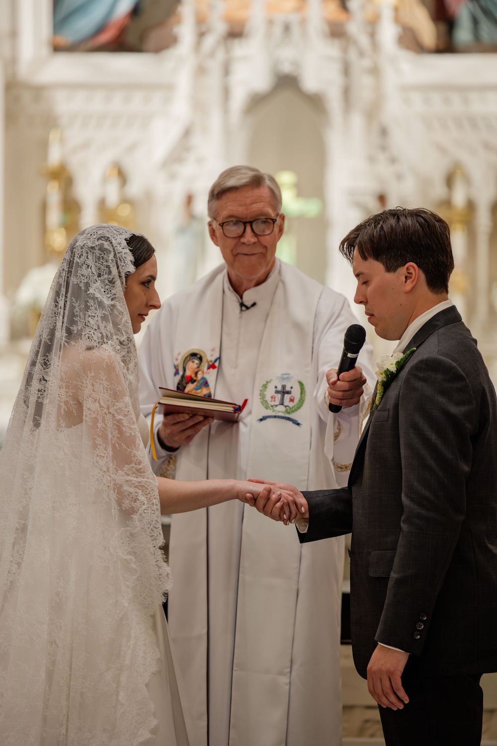 Traditional Catholic wedding ceremony with priest officiating as couple exchanges vows at the altar.