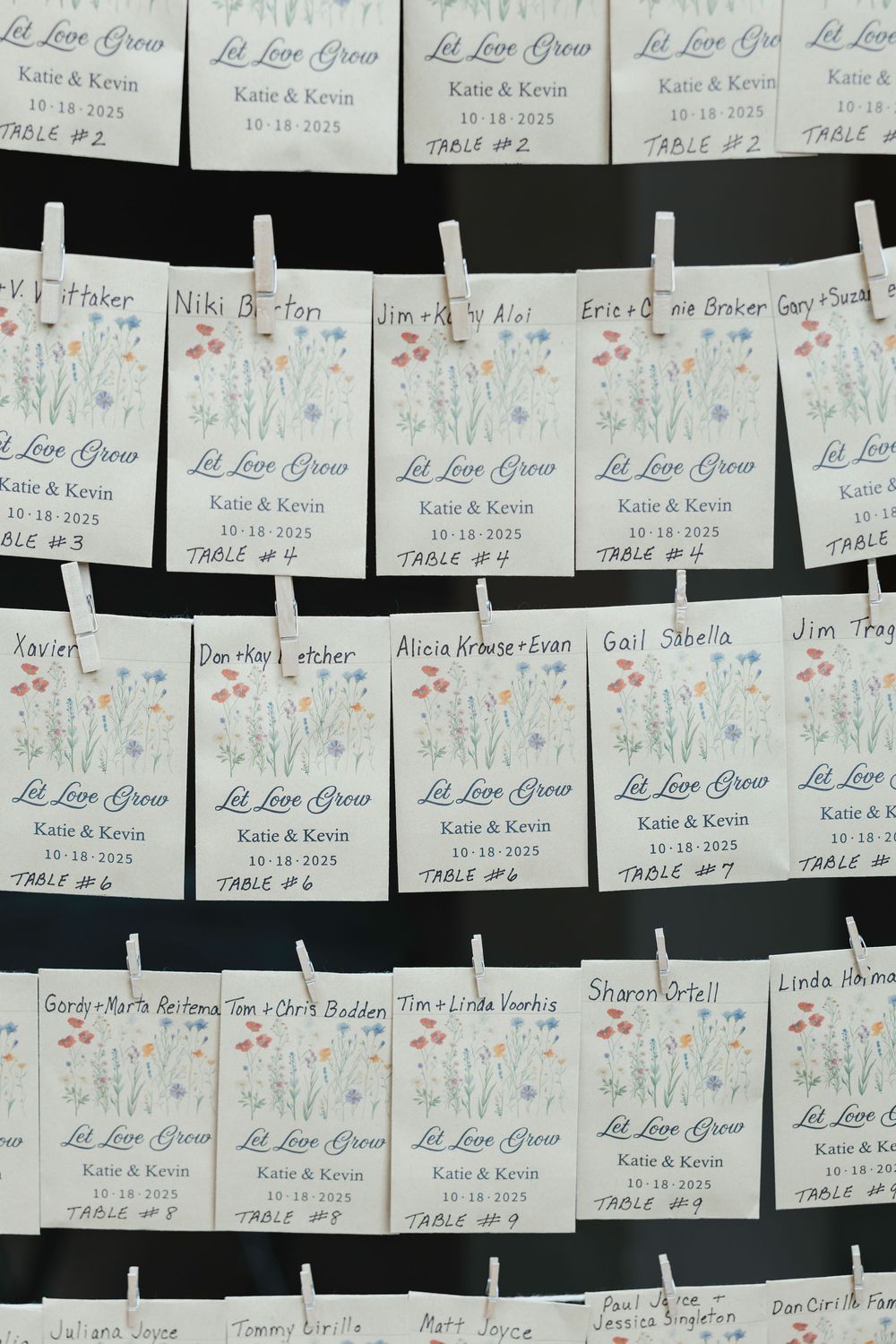 Multiple white place cards with names and dates arranged in rows against a dark background.