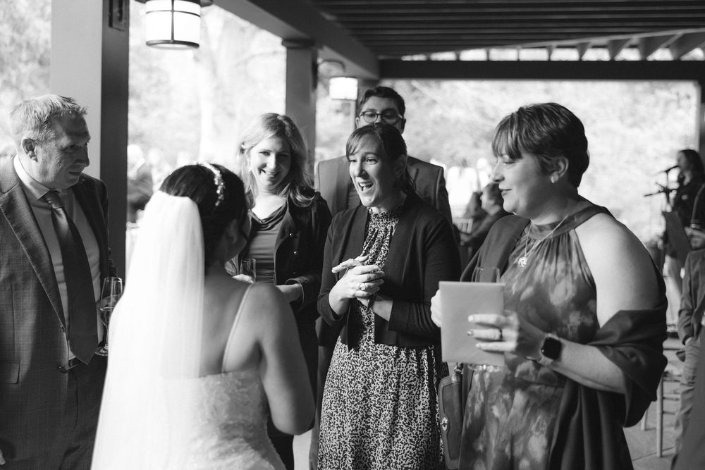 A series of black and white candid photographs showing people mingling and interacting at a social gathering.
