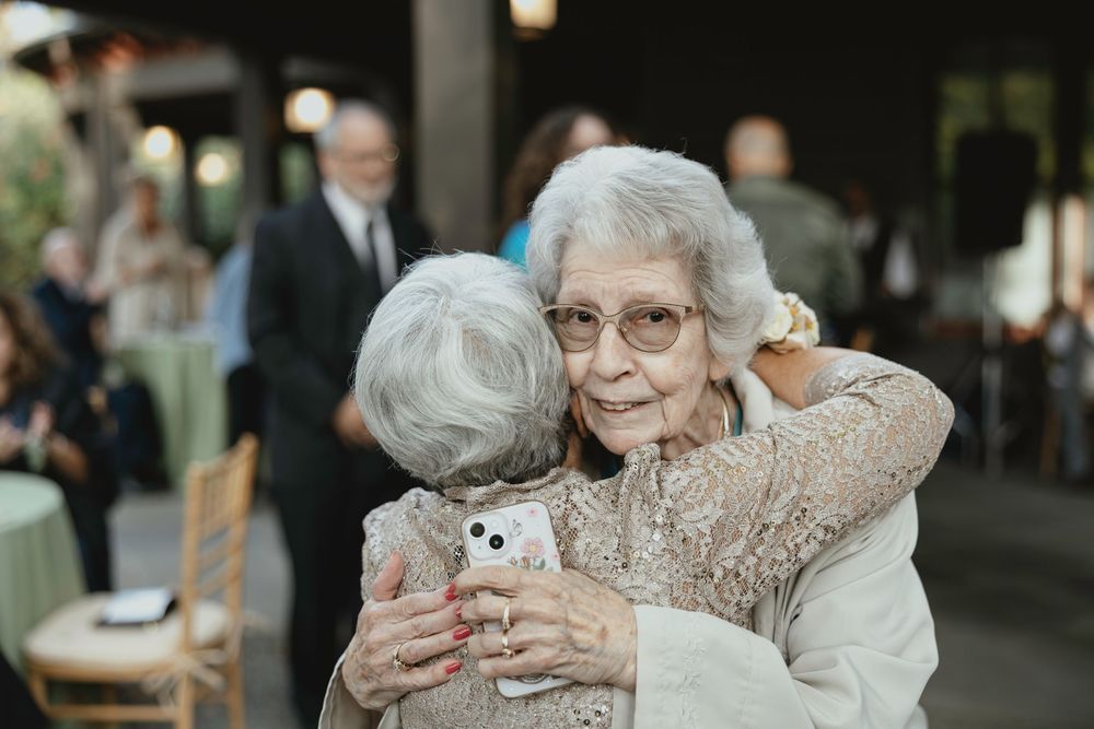 A series of candid photos showing elderly people embracing and hugging each other in joyful reunions.