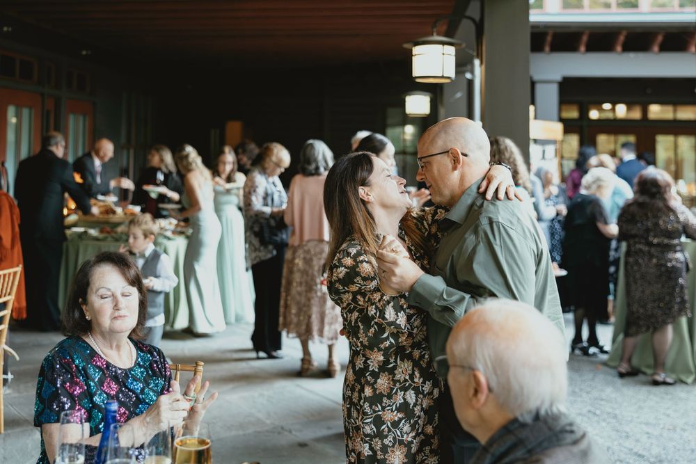 Guests mingle and socialize during an elegant reception event in a venue with soft lighting and formal attire.