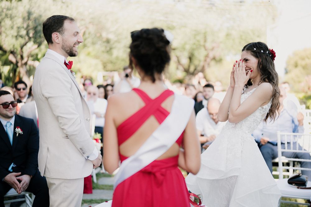 Sposa emozionata durante la cerimonia vista mare a Imperia con damigella in abito rosso