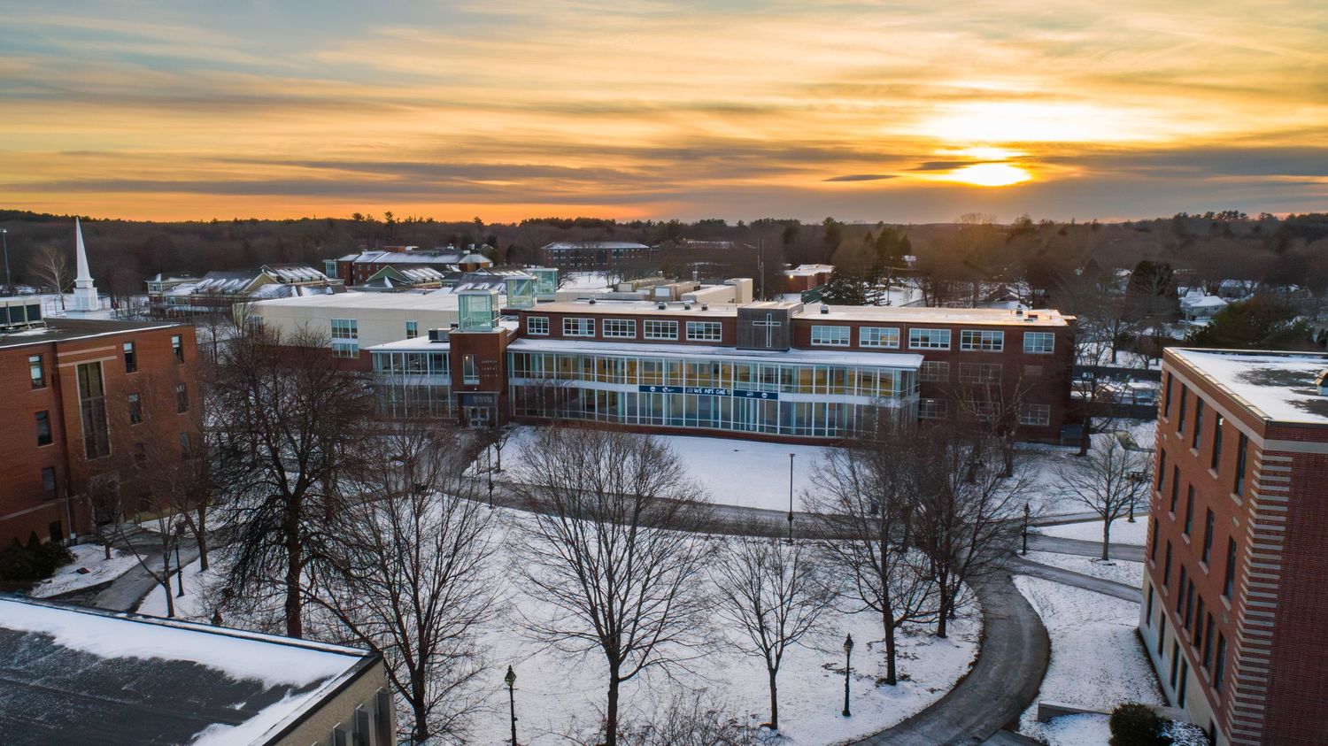 Sunset view of snow-covered campus buildings and walkways.