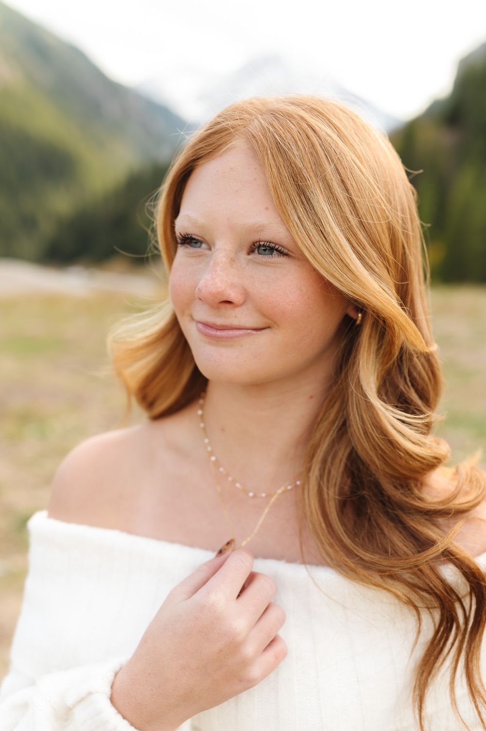 A series of outdoor portrait shots showing strawberry blonde hair flowing in natural light against a mountain backdrop.