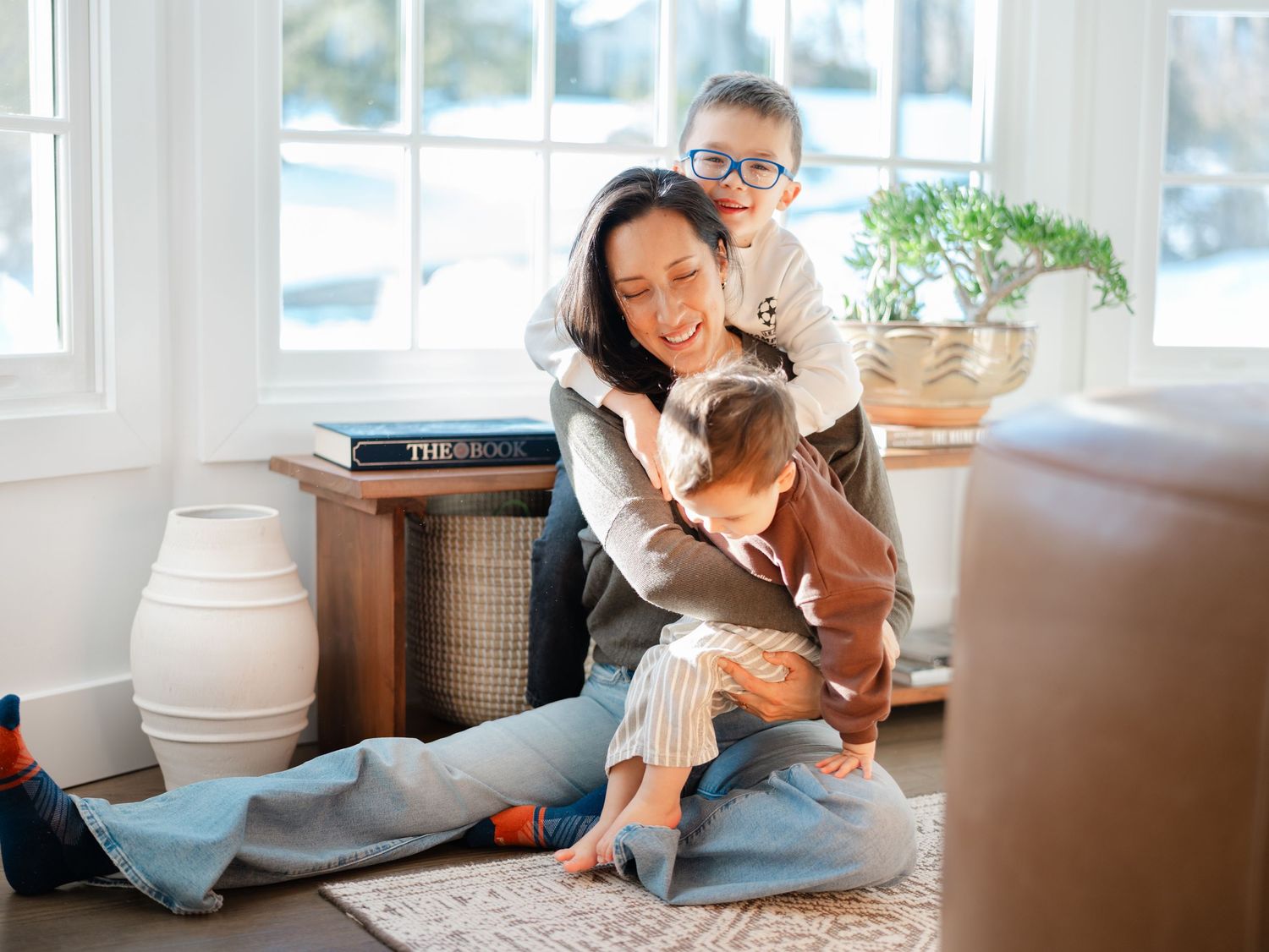 Candid family moment with a mother and two sons during an in-home family photography session in Middletown, NJ.