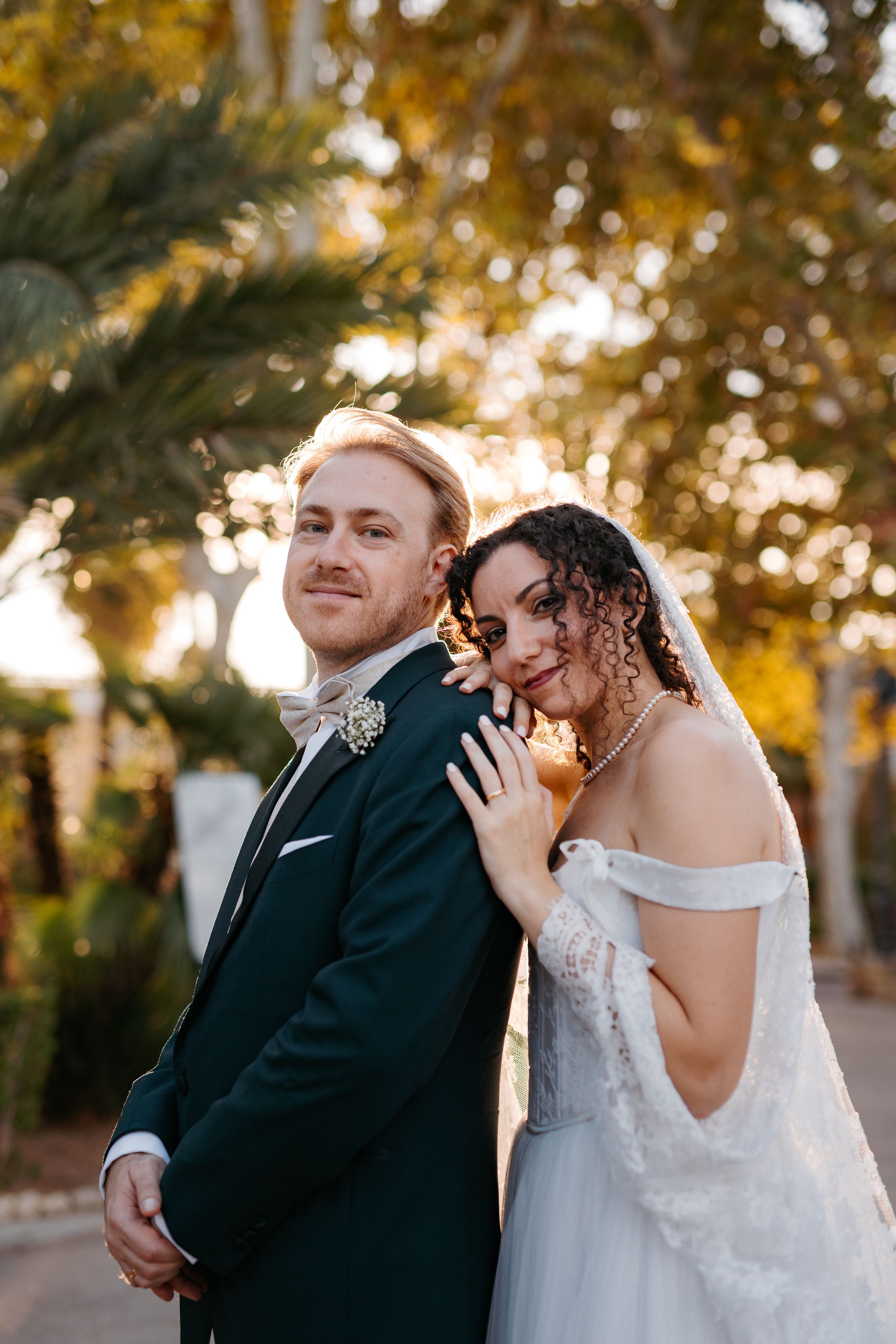 A couple shares intimate moments during their wedding photoshoot in warm autumn lighting.