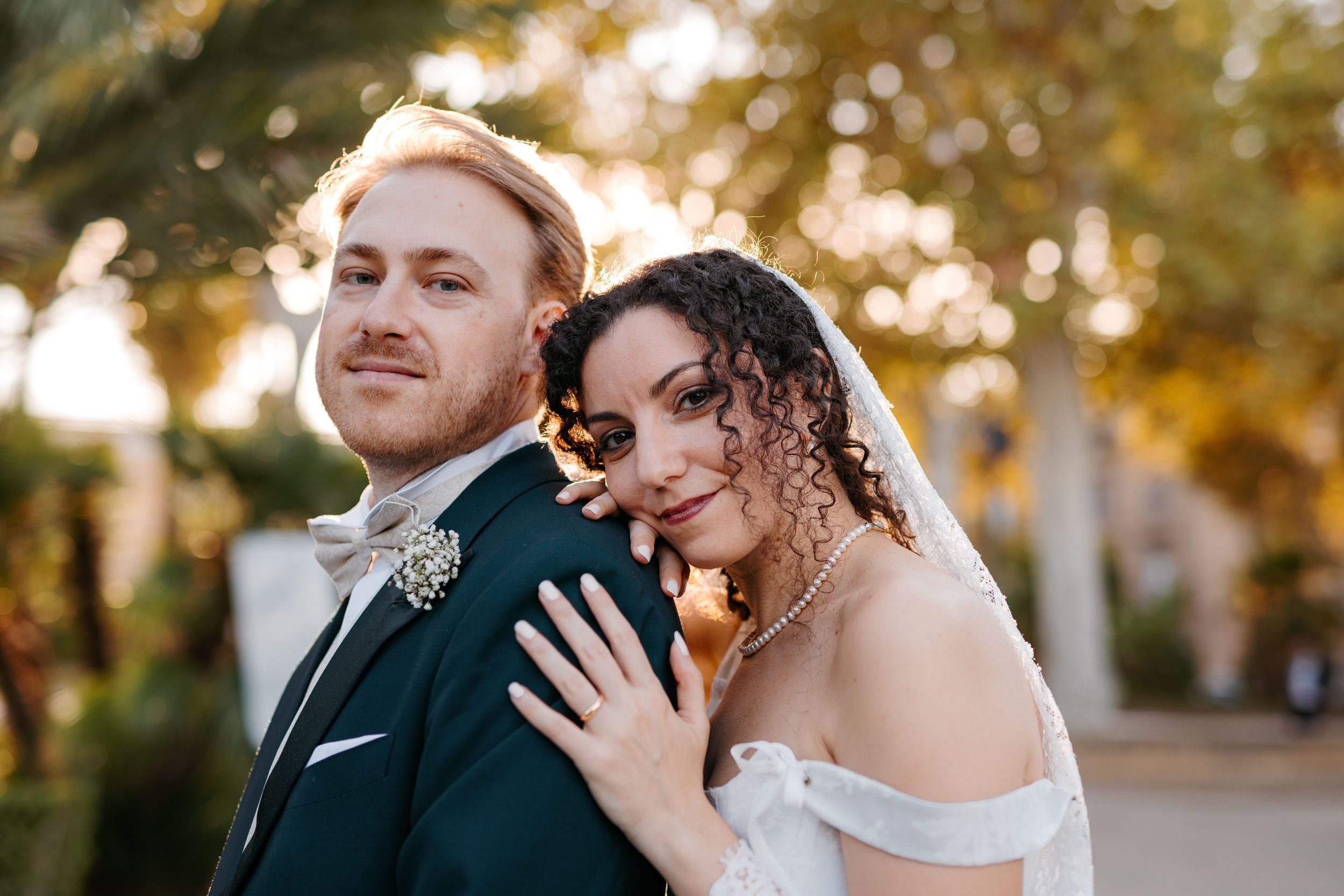 Romantic newlyweds share intimate moments in a golden autumn setting during their wedding photoshoot.