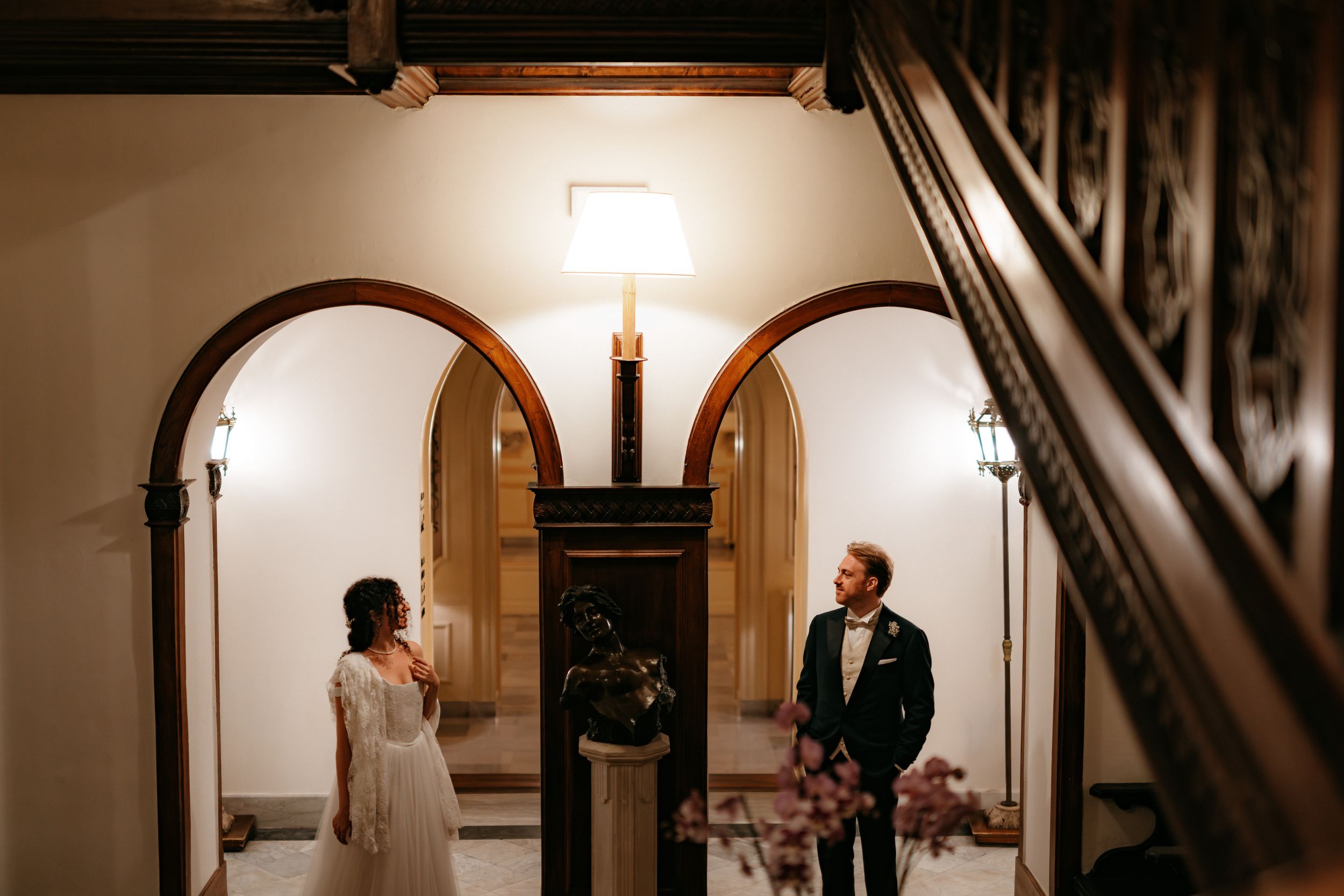 A series of dark archways in a dimly lit hallway creates a dramatic architectural perspective.