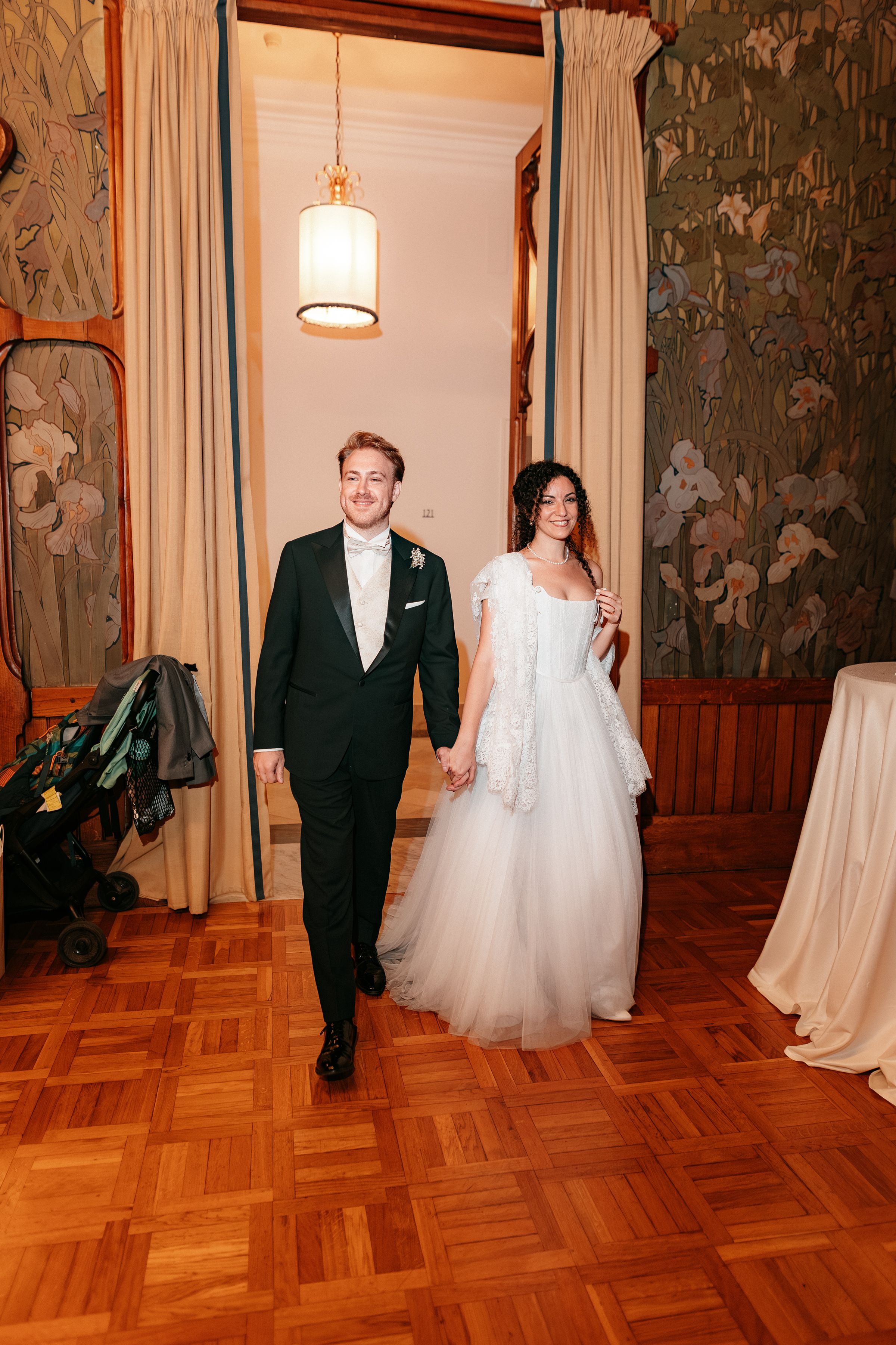 A series of four wedding photos showing a couple walking across a hardwood floor in an elegant room with decorative walls.