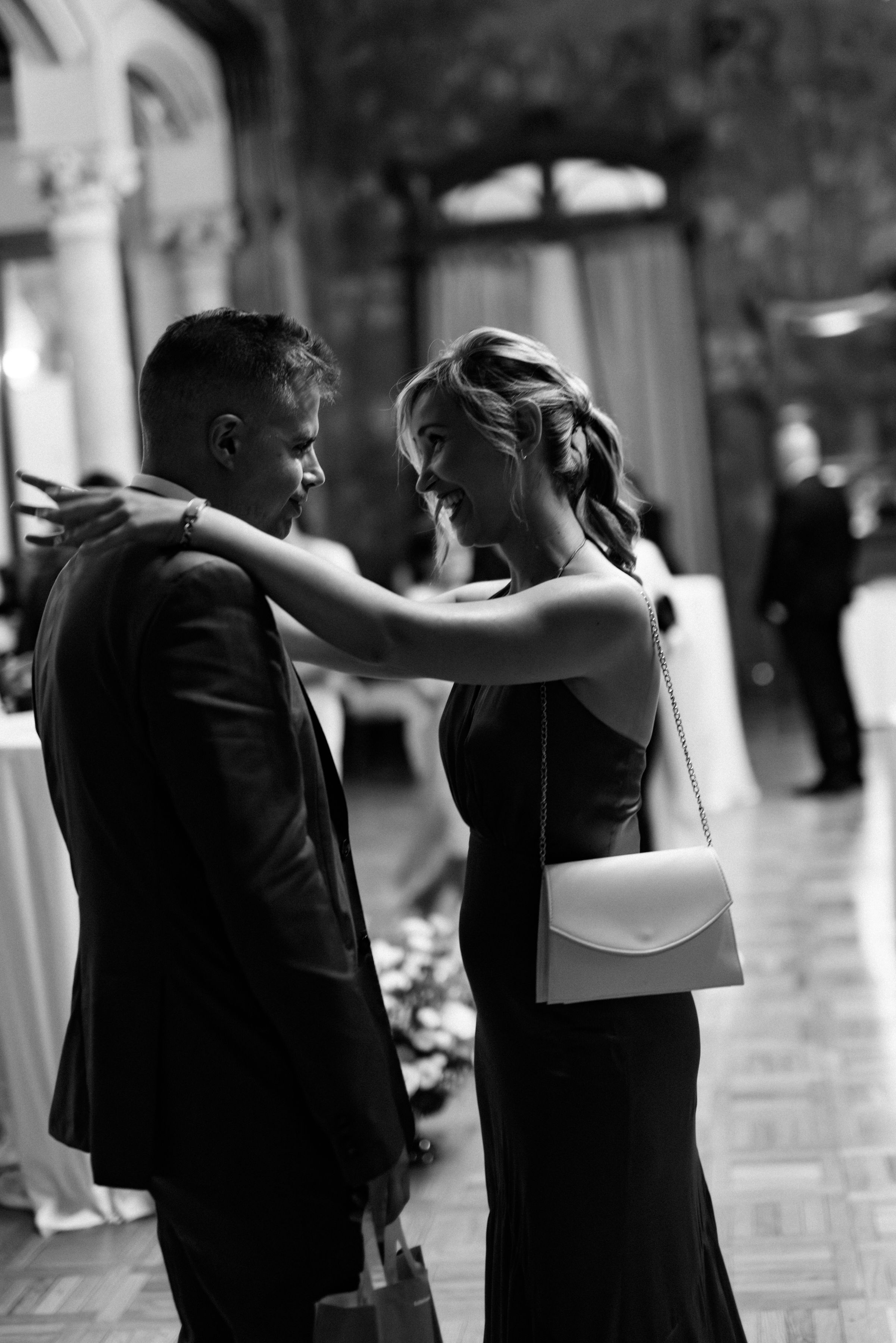A couple dances together in formal attire, creating an elegant silhouette against a light background.