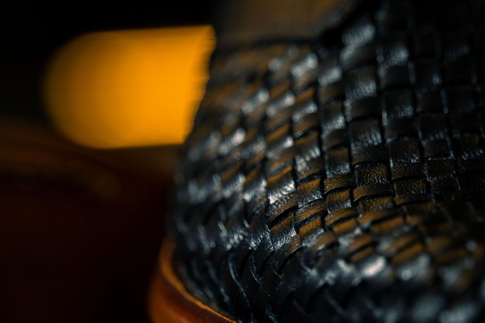 Macro de textura de cuero negro tejido con patrón intrincado.