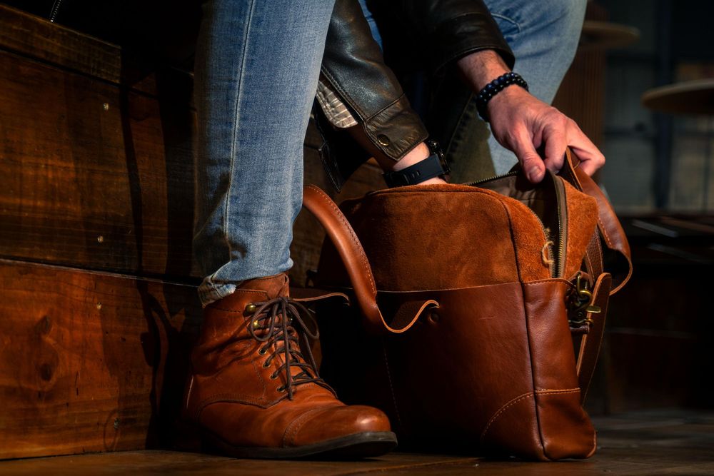 Botas de cuero marrón con cordones mostradas sobre piso de madera.