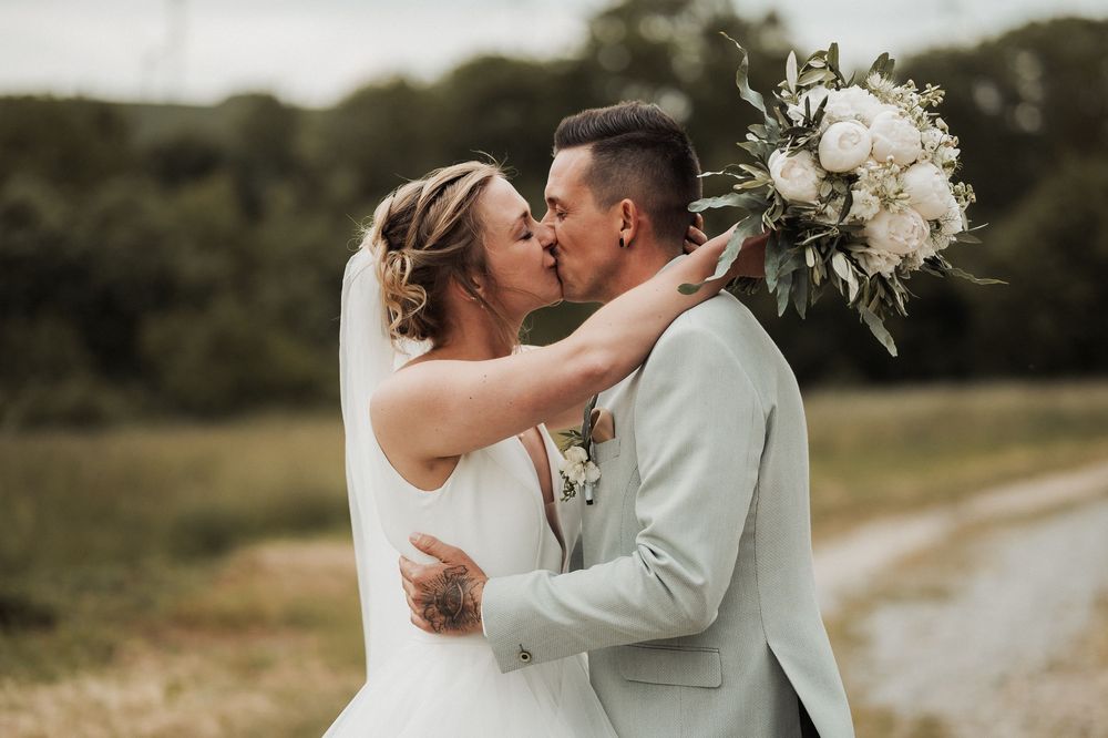 A romantic outdoor wedding photo series showing tender moments between newlyweds in a rustic natural setting.
