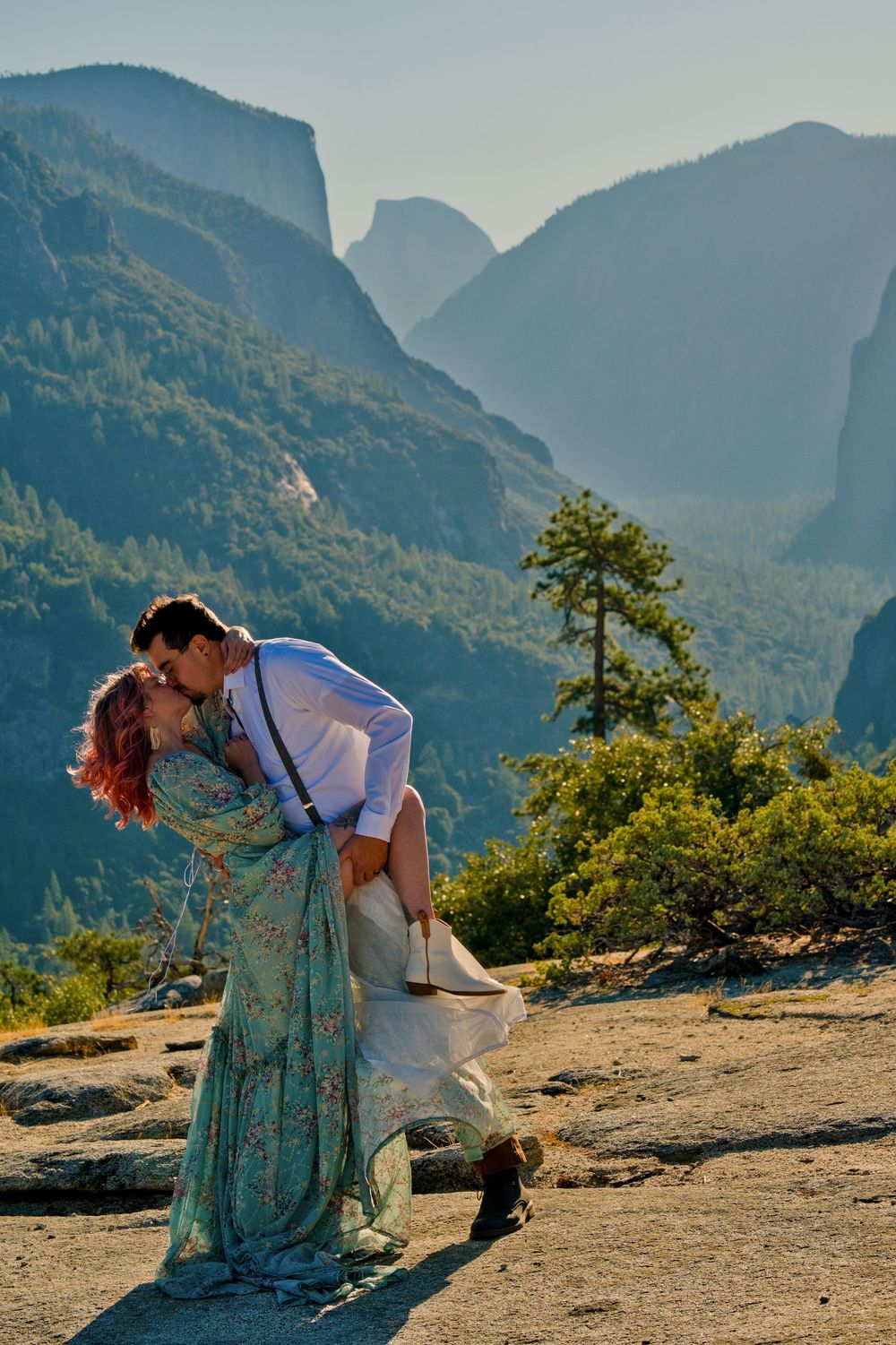 A romantic elopement couple dips against a stunning mountain backdrop in Yosemite Valley during golden hour. Half dome in the background.