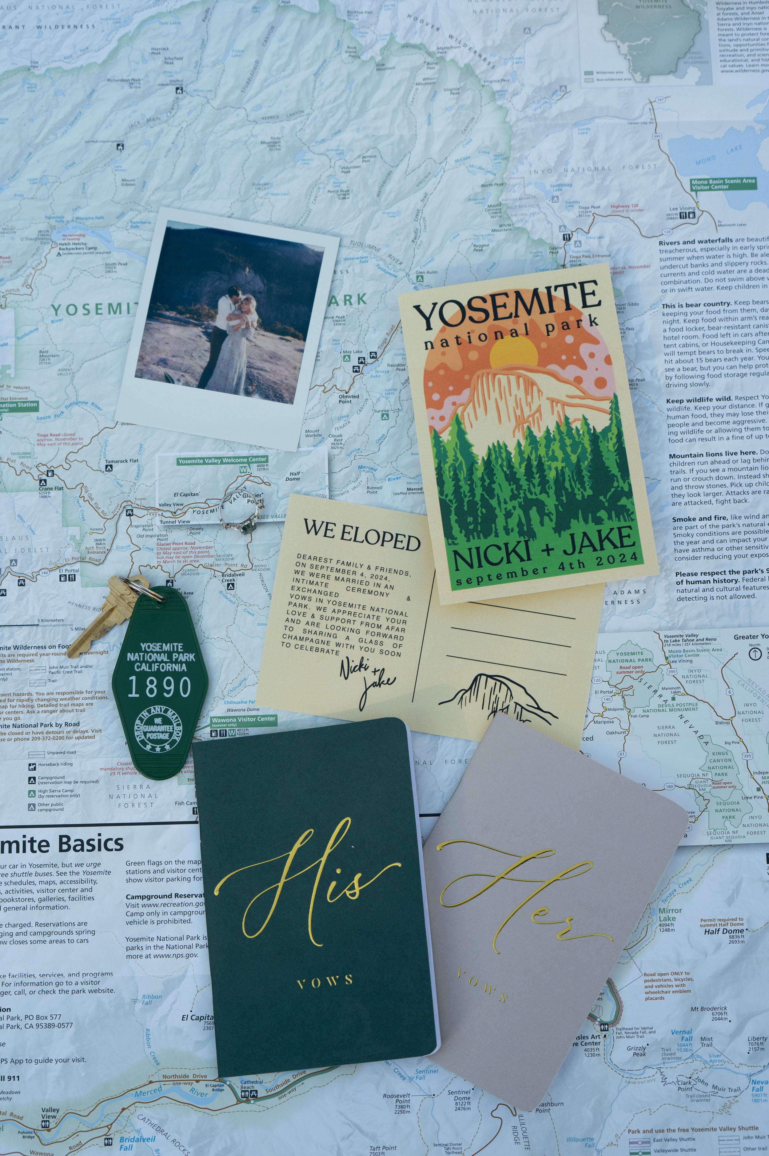 A collection of Yosemite National Park maps, guidebooks, and handwritten travel notes spread out on a surface for an elopement detail shot.