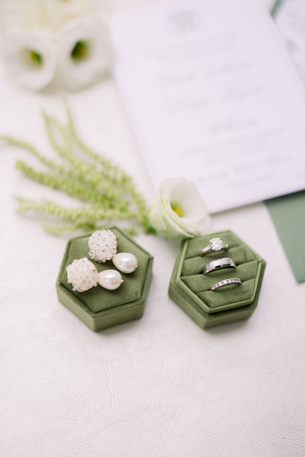 Elegant diamond engagement rings displayed in green hexagonal ring boxes with white flowers.