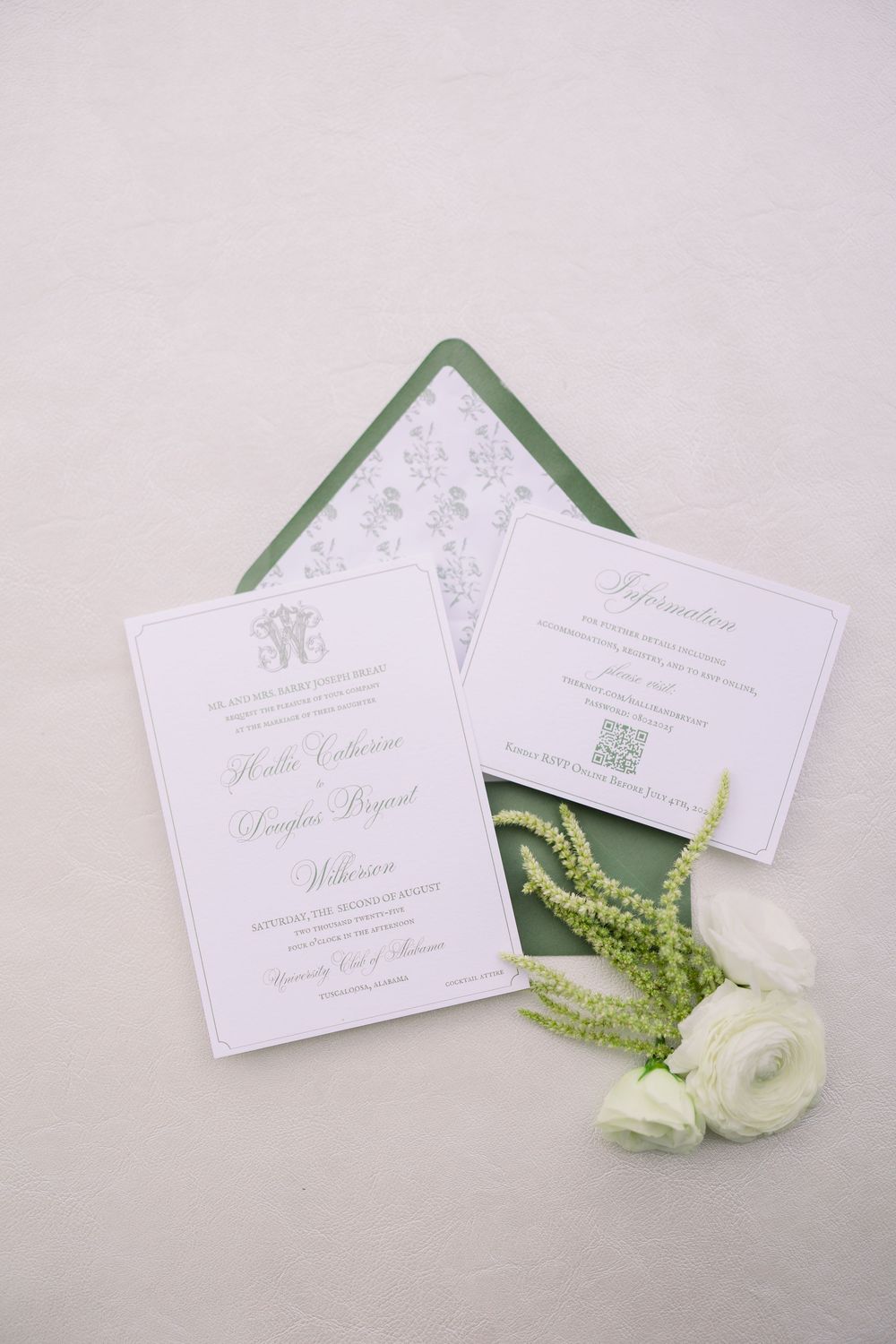 Elegant white wedding invitations with green foliage and white ranunculus flowers on light background.
