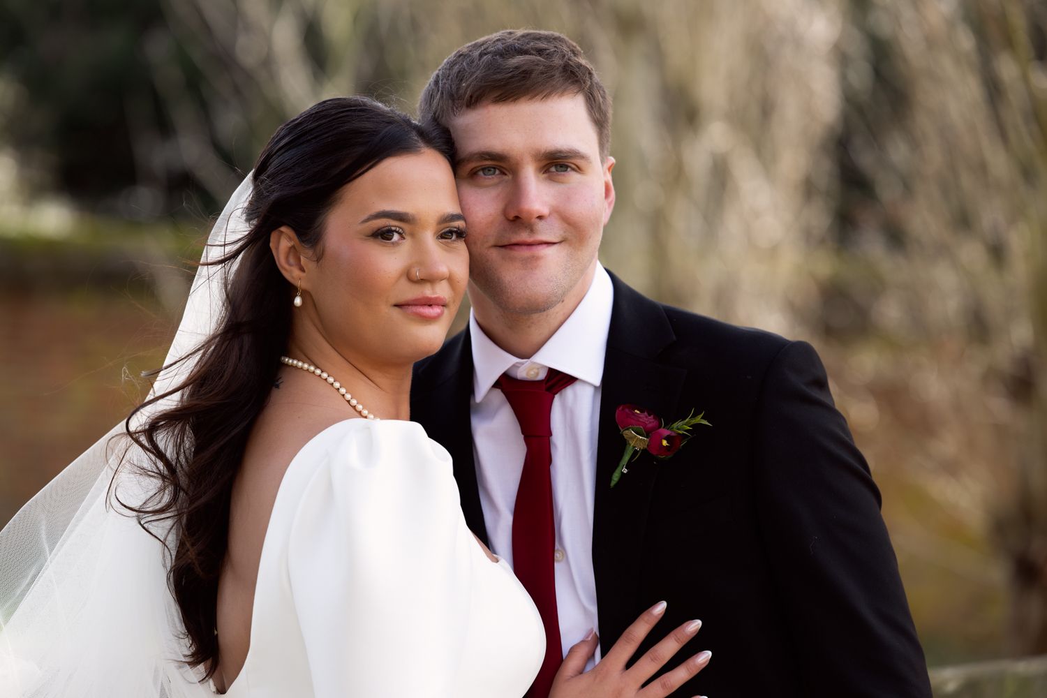 A couple in wedding attire share intimate moments outdoors during a romantic photo session in nature.