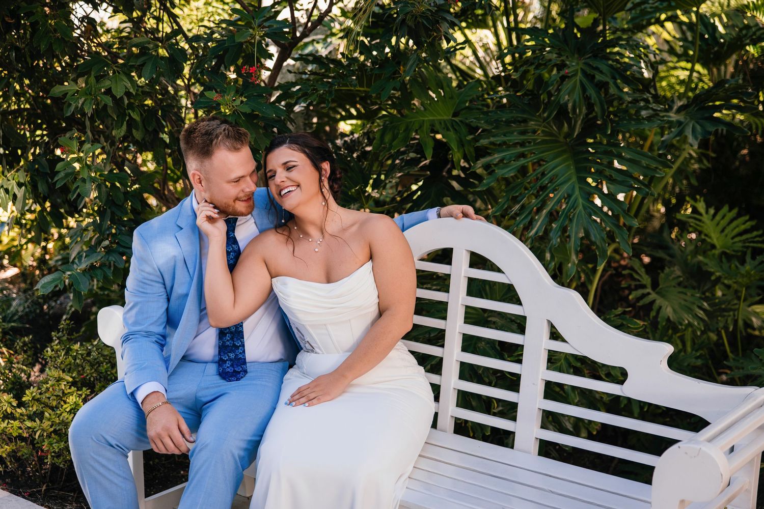 Romantic wedding portrait with flowing veil creating dreamy effect in garden setting.
