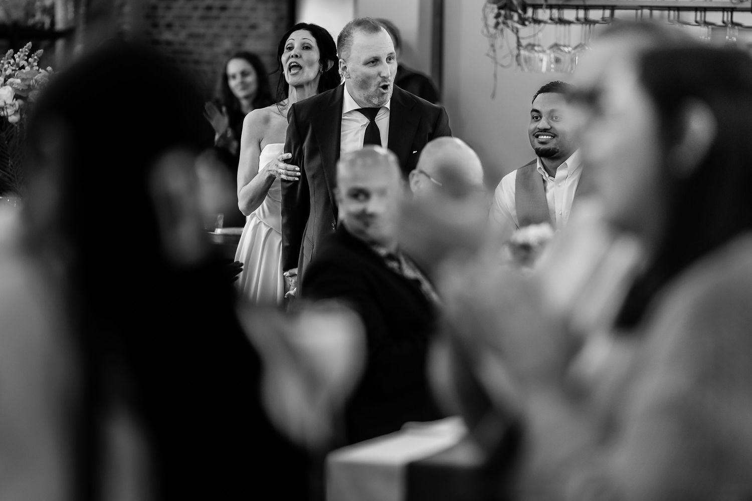 Black and white photo of people in conversation at what appears to be a business or networking event.