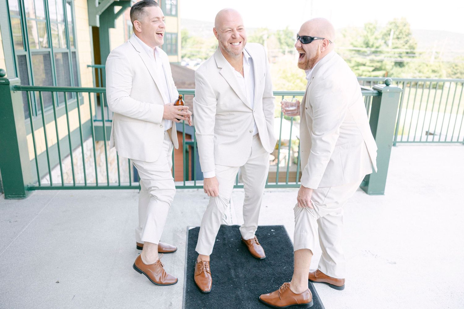 Group in white shirts and dark pants pose together at an outdoor venue with green accents.