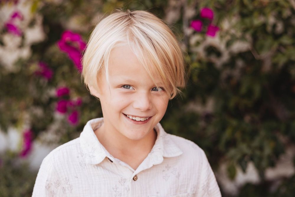 A sequence of outdoor portrait shots showing bright smiles against a floral background.