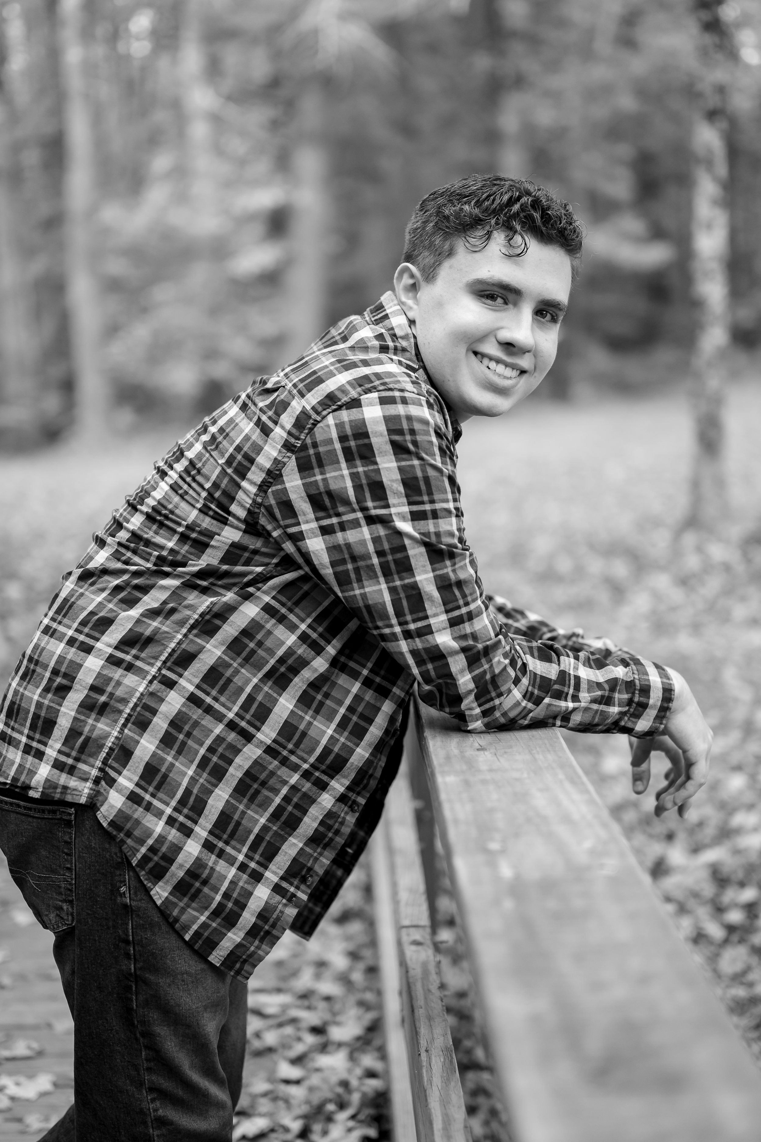 Black and white photo series showing someone in a plaid flannel shirt and jeans leaning on a wooden fence outdoors.