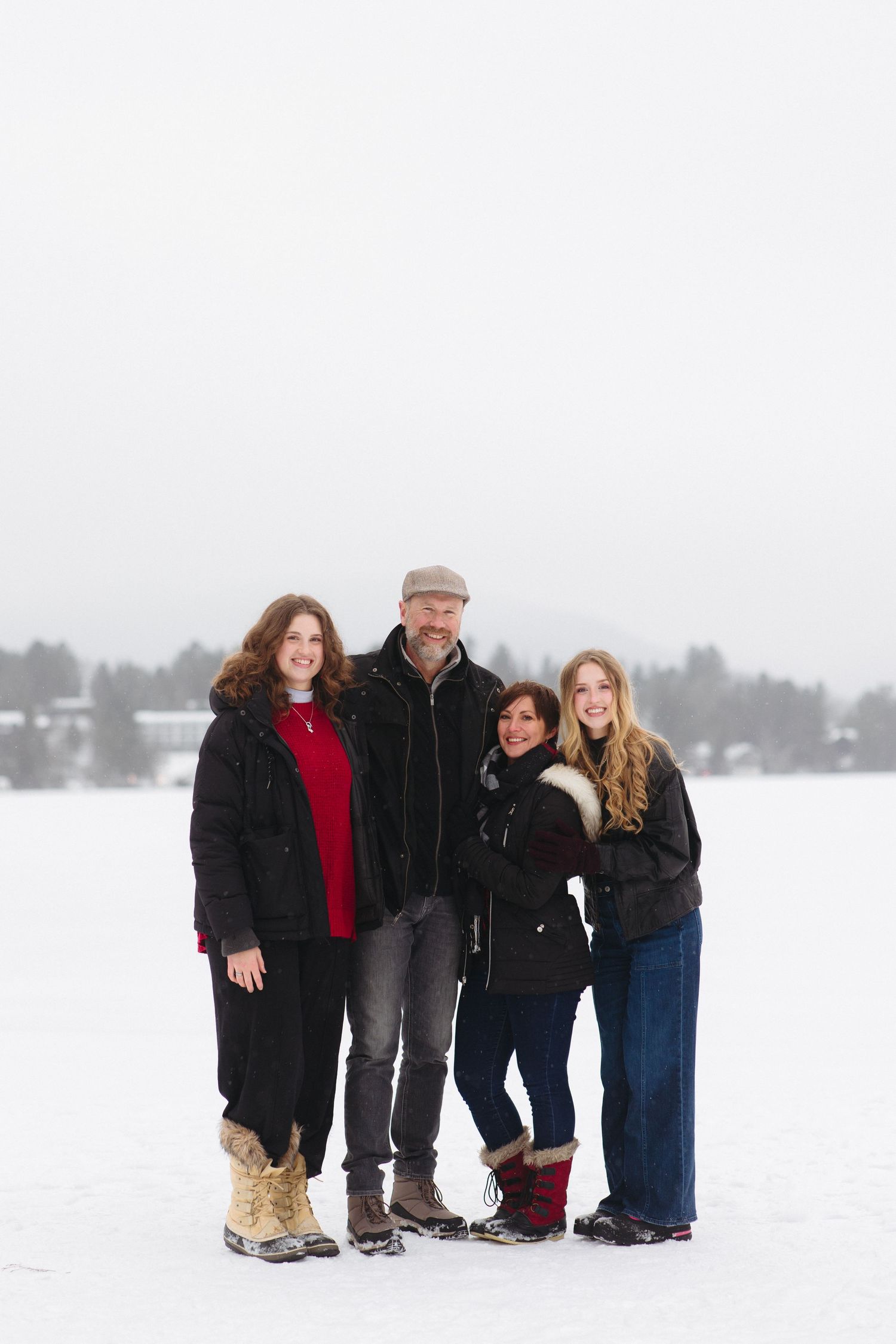 Family members huddle close together for a photo on a snow-covered frozen lake.