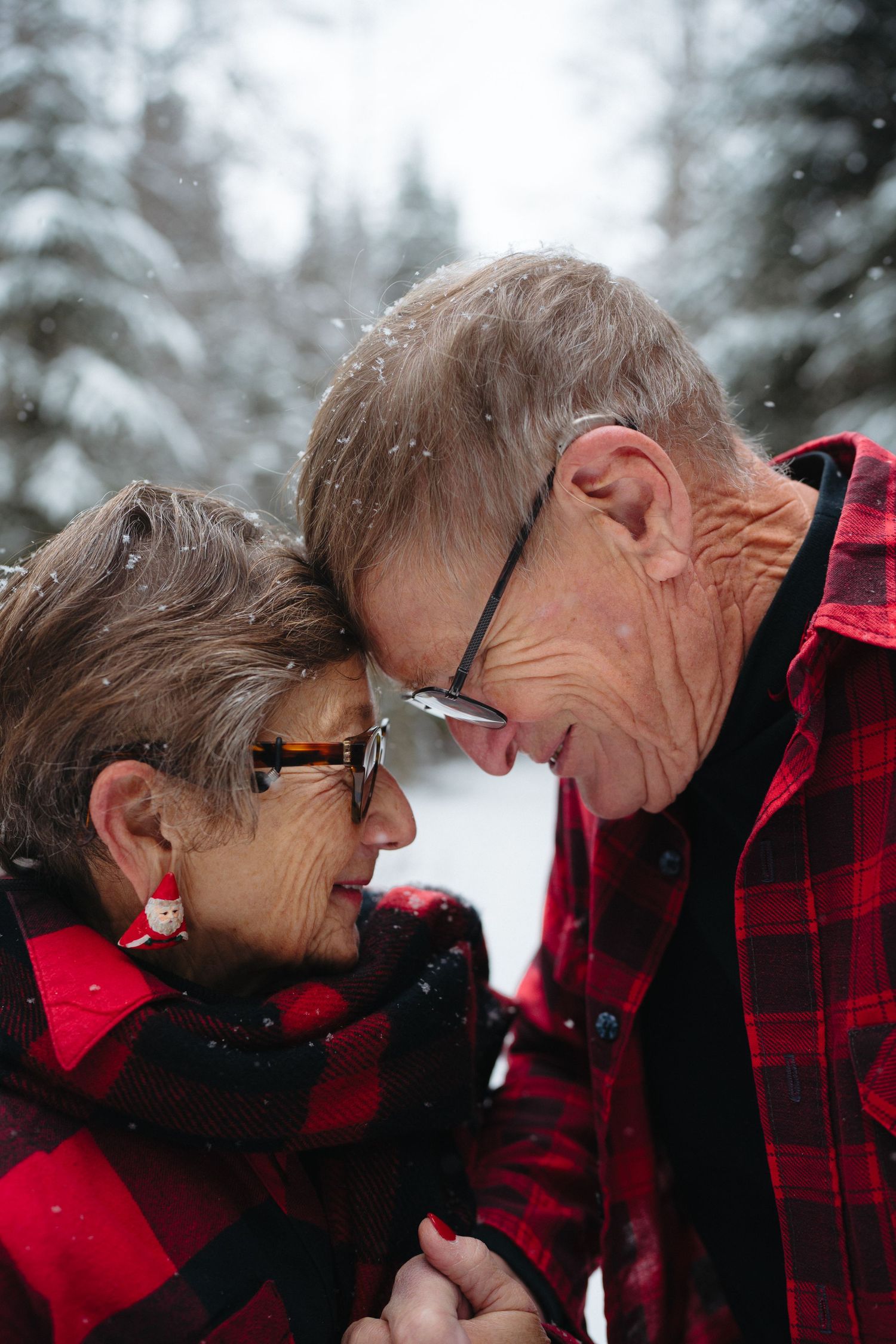 Intimate winter portrait sequence showing couple in red plaid sharing tender moments against snowy backdrop.