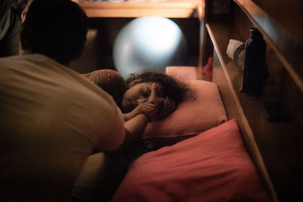 Mother resting during labor while partner holds her hand for support