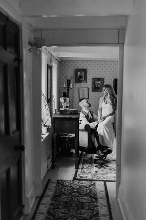 Three black and white photos show ghost-like figures in a dimly lit hallway with patterned carpeting and wall decorations.