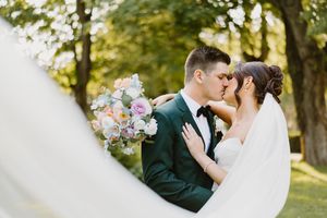 Romantic and emotional wedding moment captured in a lush outdoor garden setting during a summer celebration.