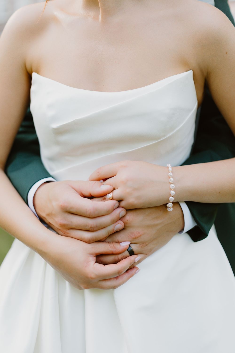 Four cropped images of hands holding white wedding dresses against a blurred background.