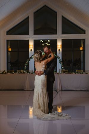 A romantic first dance in an elegant reception venue with candlelit ambiance.