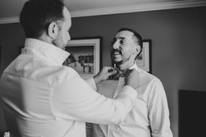 Wedding preparations showing men in white shirts getting ready.