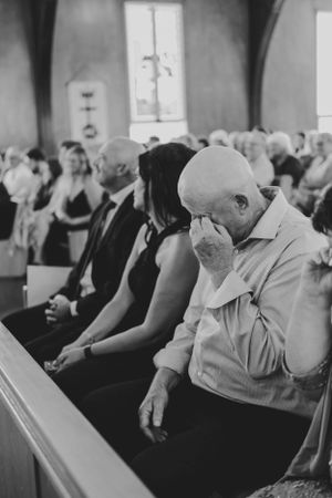 Black and white photo of wedding guests seated in church pews.